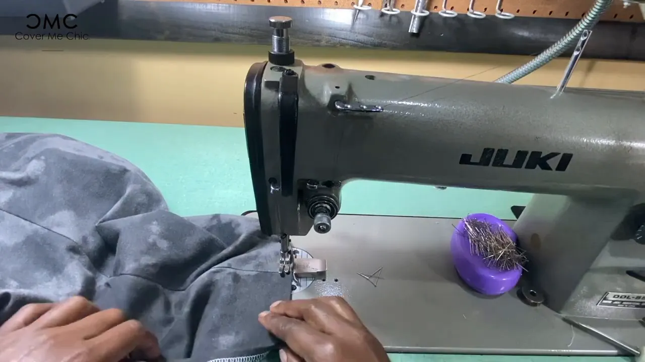 Juki sewing machine stitching the peplum hem as hands guide the fabric